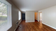 Located at 5800 Maudina Ave in Nashville, Tennessee, this single-floor unit offers a well-organized layout designed for practical, comfortable living. The main living area is a standout feature, showcasing rich, dark hardwood-style flooring that runs throughout and neutral beige walls that create a warm, inviting atmosphere. Multiple windows fitted with blinds allow natural light to fill the space while providing privacy, and views of mature trees outside add a touch of greenery. A wall-mounted heating and cooling unit serves the living area efficiently.

The galley-style kitchen is thoughtfully appointed with rich wood cabinetry offering ample storage, light countertops, a stainless steel sink, and a black electric range with an overhead exhaust hood. A doorway connects the kitchen directly to additional living spaces, supporting a functional flow throughout the unit.

The bedrooms are carpeted for comfort and each features a window with blinds, baseboard heating, and clean, neutral walls — providing quiet, restful spaces. The full bathroom includes a combination tub and shower, a wood-vanity with an integrated sink, and hardwood-style flooring, completing the unit with a cohesive design aesthetic. Overall, the space presents a clean, move-in ready interior in a convenient Nashville location.