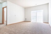 Located at 5008 Gordon Ave in Monona, WI, this one-bedroom, one-bathroom home offers a well-designed layout with thoughtful finishes throughout. The kitchen is a standout feature, boasting rich dark cabinetry, stainless steel appliances including a range, microwave, dishwasher, and refrigerator, complemented by durable hardwood-style flooring and a granite-topped peninsula with pendant lighting overhead. The peninsula seamlessly connects the kitchen to the open living area, which is carpeted and filled with natural light streaming through a large sliding glass door. The spacious bedroom features plush carpeting, a sizable window with blinds, and easy access to a dedicated closet. The full bathroom is finished with tile flooring, a dark vanity with a white countertop, and a full soaking tub with shower. A convenient in-unit laundry room houses a full-size washer and dryer with overhead shelving for added storage. Throughout the home, neutral walls, warm wood trim, and consistent finishes create a cohesive and inviting atmosphere, making this Monona residence a practical and comfortable place to call home.