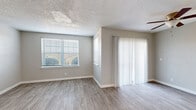 Located at 121 Hazelwood Dr in Hendersonville, Tennessee, this single-floor home offers a practical and well-appointed layout designed for comfortable everyday living. The main living area is bright and open, featuring light gray walls, wood-look flooring, and a textured ceiling. A ceiling fan provides year-round comfort, while multiple windows dressed with horizontal blinds and vertical panel drapes invite generous natural light. A sliding glass door opens directly to the outdoors, offering pleasant views of the surrounding landscape and seamless indoor-outdoor connectivity.

The kitchen is a standout feature, finished with bold dark cabinetry contrasted against light countertops and wood-look flooring. Black appliances, including a refrigerator, electric range, and built-in microwave, complement the sleek, uniform aesthetic. Ample upper and lower cabinet storage ensures functionality throughout.

The bedrooms are carpeted for warmth and comfort, each featuring neutral gray walls, white six-panel doors, and windows that allow natural light to filter in. The bathroom is accessed via a hallway and includes a dark-finished vanity with a framed mirror, a toilet, and a bathtub, all set on continuous wood-look flooring. Throughout the home, clean white baseboards and a cohesive neutral color palette create a calm, move-in-ready atmosphere.