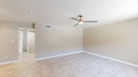 Located at 8395 Magnolia Ave in Riverside, CA, this one-bedroom, one-bathroom unit offers a practical and comfortable single-floor layout. Light-toned tile flooring runs consistently throughout the entire space, creating a cohesive and easy-to-maintain interior. The open living room greets you at the entrance, featuring a ceiling fan with light, a large window that allows natural light and views of the surrounding community, and a wall-mounted AC unit for year-round climate control. The galley-style kitchen is efficiently designed with white cabinetry extending to the ceiling for generous storage, a stainless steel refrigerator, a gas range with overhead ventilation, a built-in sink, and a window at the far end that keeps the space bright. The bedroom is a well-sized retreat, equipped with its own ceiling fan, a natural light-providing window, and mirrored sliding closet doors that enhance the sense of space. A hallway connects the main rooms to the bathroom, which features a single-vanity with white cabinetry and a stone-toned countertop, brushed gold hardware accents, a large mirror, and a tub-shower combo adorned with elegant marble-style tile surround. The unit's neutral warm-beige walls throughout lend a clean, move-in-ready ambiance.