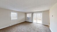 Located at 203 Ridgefield Dr in Middletown, Connecticut, this two-bedroom, one-bathroom residence offers a functional and comfortable single-floor layout. The living room is a generously sized, light-filled space featuring wall-to-wall carpeting, multiple windows with blinds, a wall-unit air conditioner, baseboard heating, and a sliding glass door that opens to an outdoor view of surrounding trees — bringing in ample natural light and a sense of openness. The textured ceiling adds a classic touch throughout the common areas.

The kitchen is well-appointed with white cabinetry, dark granite-style countertops, tile flooring, and a full suite of appliances including an electric range, dishwasher, and refrigerator. A bright window and a closet add practicality to the space.

The primary bedroom is a comfortable retreat with carpet flooring, multiple windows, baseboard heating, and a set of louvered bifold closet doors providing organized storage with built-in shelving and hanging rods. The second bedroom is similarly carpeted and bright, with access to additional hallway storage.

The bathroom features a full tub-shower combination with chrome fixtures and tile flooring. A dedicated utility room rounds out the layout, adding everyday convenience to this well-organized Middletown residence.