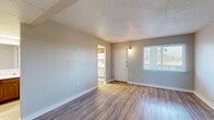 Located at 902 Greenland Dr in Murfreesboro, TN, this single-floor, 2-bedroom, 2-bathroom unit offers a practical and well-organized layout. The combined living and dining area greets you upon entry, featuring light wood-look flooring, neutral gray walls, a textured ceiling, and a large window that brings in natural light. A front door with an overhead wall sconce adds a welcoming touch, with a clear sightline into the adjacent utility area housing in-unit washer and dryer hookups. The galley-style kitchen is efficiently arranged with warm wood cabinetry, white countertops, a double-coil electric range, built-in microwave, refrigerator, and a stainless steel sink — all set on light-toned flooring. Both bedrooms are carpeted with wood-look flooring, neutral walls, textured ceilings, and windows that allow natural light. The primary bedroom includes a closet with louvered doors. Each bedroom connects to its own bathroom; one bathroom features a clean, white-tiled walk-in shower with chrome fixtures. Throughout the unit, consistent use of light, neutral tones and wood-look flooring creates a cohesive and functional living environment suited for everyday comfort.