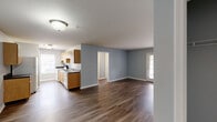 Located at 3825 Hixson Pike in Chattanooga, Tennessee, this single-floor residence offers 2 bedrooms and 2 bathrooms in a well-organized, functional layout. The open-concept kitchen and living area serves as the heart of the home, featuring warm honey-toned wood cabinetry, dark countertops with a double-basin sink, white appliances including a dishwasher and refrigerator, and rich dark hardwood-style flooring that extends throughout the entire unit. Soft blue-gray walls lend a calm, cohesive tone to every room.

The living area is bright and welcoming, highlighted by a set of French doors that invite natural light and provide outdoor access. The primary bedroom is generously sized, offering a comfortable retreat with its own closet and natural light from a window with outdoor views. The second bedroom is equally well-appointed, also benefiting from natural light and a dedicated closet.

Both bathrooms continue the consistent design language of the home, with hardwood-style flooring, wood vanity cabinetry, and dark countertops. One bathroom features a full tiled tub-shower combination with safety grab bars. A connecting hallway ties the layout together seamlessly, offering practical flow between all rooms. The result is a clean, move-in-ready residence with a comfortable, understated character.
