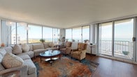 Located along Milwaukee's prestigious North Prospect Avenue, this single-floor residence offers an exceptional lakefront living experience with sweeping, unobstructed views of Lake Michigan. The expansive living room is a standout feature, lined with floor-to-ceiling windows and a sliding glass door leading to a private balcony, flooding the space with natural light and framing breathtaking water vistas. Rich hardwood flooring runs throughout the main living and dining areas, adding warmth and elegance to the open layout. The dining area continues the lake-view theme, with a large window perfectly positioned to provide scenic backdrop for everyday meals. The kitchen is well-appointed with warm wood cabinetry, granite countertops, tile flooring, and stainless steel appliances, including a built-in dishwasher. A secondary sitting area provides additional flexible living space. The generously sized bedroom features plush carpeting, ample natural light, and a serene, restful ambiance. The bathroom is finished with granite countertops, wood cabinetry, and tile flooring. Throughout the residence, the interplay of natural light, lake views, and quality finishes creates a refined and comfortable living environment.