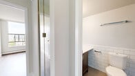 Located at 1501 Haro St in Vancouver's desirable West End neighbourhood, this two-bedroom unit offers a well-designed single-floor layout with a bright, functional interior. Light-toned hardwood-style flooring runs throughout, complementing the clean, neutral palette of the walls and trim.

The galley-style kitchen is thoughtfully appointed with white shaker cabinetry, grey countertops, a subway tile backsplash, and stainless steel appliances including a refrigerator, dishwasher, and range. A large window at the end of the kitchen frames sweeping views of the Vancouver skyline and North Shore mountains, filling the space with natural light.

The open living area is generously proportioned, featuring baseboard heating and large floor-to-ceiling windows that offer elevated panoramic views of the city and surrounding greenery. The spacious primary bedroom includes mirrored sliding closet doors and connects to a well-lit ensuite bathroom. The ensuite features dark wood cabinetry, a glass-enclosed shower, and classic white subway tile. A second bedroom also benefits from large windows with city views and mirrored closet storage. A central hallway connects all rooms efficiently, completing this well-laid-out urban residence.