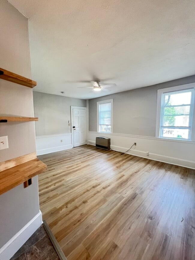 Updated living room with high ceilings, new flooring, ceiling fan, great natural light - 5 Chapel St
