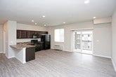 This single-floor residence offers a thoughtfully designed open-concept layout that connects the living, dining, and kitchen areas into one cohesive and functional space. Light-toned luxury vinyl plank flooring runs throughout the main living areas, complementing the neutral wall tones and recessed lighting that keep the space feeling bright and airy.

The living area is generously sized and features a sliding glass door that opens to a private balcony, allowing natural light to fill the room and providing outdoor views. The kitchen is well-equipped with rich dark espresso cabinetry, granite-style countertops, and a full suite of black appliances including an electric range, microwave, dishwasher, and refrigerator. A double-basin sink and ample cabinet storage add to the kitchen's practicality. A dedicated in-unit laundry area with a washer and dryer is conveniently accessible directly from the kitchen.

The bedroom is finished with plush wall-to-wall carpeting, a ceiling fan with light fixture, a wall-mounted HVAC unit, and a window that brings in natural light. The bathroom features dark wood cabinetry paired with granite-style countertops, a large vanity mirror, and overhead lighting, offering a clean and functional design. Throughout the residence, white trim and baseboards provide a polished, cohesive aesthetic.