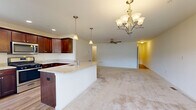 Located at 3607 Lilac Ln in Enola, PA, this two-story, 4-bedroom, 2-bathroom home offers a well-organized layout across two floors. The main level features an open-concept kitchen and living area highlighted by rich dark wood cabinetry, granite countertops, a large center island with a sink, and stainless steel appliances. Pendant lighting and a chandelier add warmth to the space, while a ceiling fan keeps the living area comfortable. Hardwood-style flooring transitions seamlessly into plush carpeting throughout. A hallway with flush-mount lighting connects the main living areas to the attached garage, which includes an automatic opener. A dedicated laundry room on the main level houses a full-size washer and dryer with overhead wire shelving. Upstairs, the generously sized primary bedroom offers a ceiling fan and easy access to additional rooms. Three additional bedrooms feature neutral carpet, closets with built-in shelving, and clean white paneled doors. The full bathroom is finished with stone-look tile flooring, dark wood vanity cabinetry, a white countertop, and a tub/shower combination. A utility room and staircase complete the home's functional and practical floor plan.
