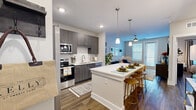 Located at 2002 Wilson Ave in Panama City, FL, this thoughtfully designed one-bedroom, one-bathroom residence offers a comfortable and efficient single-floor layout. The open-concept living, dining, and kitchen area serves as the heart of the home, anchored by warm wood-look flooring and neutral tones throughout. The kitchen is a standout feature, equipped with stainless steel appliances including a French door refrigerator, electric range, built-in microwave, and dishwasher. Dark wood-grain cabinetry with sleek hardware reaches to the ceiling, complemented by a white subway tile backsplash and crisp quartz countertops. A large kitchen island with bar seating and pendant lighting above creates an ideal space for dining and entertaining. The living room benefits from natural light through large windows and a patio door, with a ceiling fan adding comfort. The bedroom is a serene retreat with ample natural light, a ceiling fan, and a dedicated closet. The bathroom features a modern vanity with quartz countertop, wood-grain cabinetry, and wood-look flooring. A dedicated in-unit laundry room houses a full-size washer and dryer with overhead shelving. The space also includes a private patio, completing this well-appointed residence.