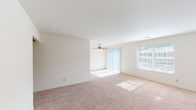 Located at 5545 Westwood Northern Blvd in Cincinnati, Ohio, this single-floor unit offers a well-organized and functional layout throughout. The expansive living area is a standout feature, finished with plush wall-to-wall carpeting and bathed in natural light streaming through large sliding glass doors fitted with vertical blinds, as well as a side window. A ceiling fan adds both comfort and a finishing touch to this generously sized open living space.

The layout extends into multiple bedrooms, each carpeted and illuminated by natural light through individual windows with blinds. The rooms offer ample wall space and a clean, neutral palette throughout, providing a versatile backdrop for a variety of furnishing styles.

The galley-style kitchen is efficiently designed with warm wood cabinetry lining both sides, offering abundant upper and lower storage. Light-toned countertops, a stainless steel sink, and tile flooring complete the practical cooking space.

The bathrooms feature classic tile flooring and tiled walls, maintaining a clean and functional aesthetic. One bedroom includes direct access to a walk-in closet alongside a private bathroom, adding a layer of convenience. A carpeted hallway connects the rooms seamlessly, contributing to the unit's cohesive and accessible single-level flow.