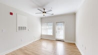Located at 3815 Maypop Cir in Myrtle Beach, SC, this single-story, 3-bedroom, 2-bathroom home offers a clean and functional layout accented by neutral tones throughout. Light hardwood flooring runs through the living areas and bedrooms, complemented by crown molding and white baseboards that lend a polished, cohesive look to every room. The living room is bright and airy, featuring a ceiling fan, large windows with blinds, and direct access to the exterior via a glass-panel door, inviting natural light into the space. The galley-style kitchen is well-appointed with white shaker cabinetry, dark granite countertops, stainless steel appliances including a range, microwave, and refrigerator, and neutral tile flooring that extends into the adjoining dining area. The dining space is highlighted by a pendant light fixture and crown molding detail. Each of the three bedrooms features hardwood flooring, ceiling fans, and natural light from windows. The primary bedroom includes a well-sized walk-in closet with multi-tier wire shelving. The bathrooms feature tile flooring, white cabinetry with ample storage, and a tub-shower combination. The home's straightforward, efficient design makes it a practical and comfortable residence in Myrtle Beach.