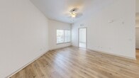 Located at 6350 Vineland Rd in Orlando, FL 32819, this 2-bedroom, 1-bathroom residence offers a well-designed single-floor layout with a bright, neutral color palette throughout. The open-concept living area features light wood-look flooring and soaring ceilings that enhance the sense of spaciousness, with windows fitted with blinds allowing ample natural light to fill the space.

The kitchen is a standout feature, showcasing rich dark wood cabinetry, granite countertops with a classic subway tile backsplash, and a large center island with a built-in sink and pendant lighting overhead. Stainless steel appliances, including a range, over-the-range microwave, and French door refrigerator, complete this well-appointed cooking space. Tile flooring runs throughout the kitchen.

The primary bedroom offers wood-look flooring, vaulted ceilings, and a bright window with outdoor views, while the second bedroom features plush carpeting, a walk-in closet, and a sliding glass door opening to a private balcony. The full bathroom includes tile flooring and a soaking tub with tiled surround. A dedicated laundry room with full-size washer and dryer adds everyday convenience. Two closets provide ample storage throughout the home.