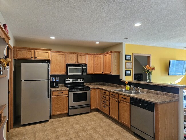 Eat-in kitchen with matching appliances and breakfast bar. - 212 Alydar Dr