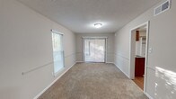 This single-floor, 3-bedroom, 2-bathroom home in Essex offers a practical and comfortable layout designed for everyday living. The spacious living area features plush wall-to-wall carpeting, a textured ceiling, and multiple windows with blinds that allow generous natural light to filter in. Sliding glass doors provide access to the outdoors, enhancing the open feel of the main living space.

Each of the three bedrooms is carpeted and equipped with a ceiling fan and light fixture. The bedrooms feature ample closet space, including both walk-in and standard closets, and neutral-toned walls that create a calm, versatile atmosphere.

The kitchen is outfitted with warm wood cabinetry, dark granite-style countertops, a stainless steel sink, a dishwasher, and a refrigerator, all complemented by wood-look flooring that adds warmth and durability.

The two bathrooms are clean and functional. One features a vanity with rich wood cabinetry and granite-style countertops paired with a tub-shower combo, while the second offers a straightforward tub-shower combination with brushed nickel fixtures. Both bathrooms include wood-look flooring for a cohesive aesthetic throughout the home.