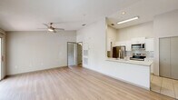 Located at 2150 Lake Highland Blvd in Lakeland, FL, this one-bedroom, one-bathroom unit offers a well-designed single-floor layout that maximizes its living space. The open-concept living and dining area is bright and airy, highlighted by vaulted ceilings, a ceiling fan, and light-toned wood-style flooring that flows throughout the main living areas. Large windows and a sliding glass door flood the space with natural light and provide direct access to a private balcony, which offers pleasant outdoor views of the surrounding greenery. The kitchen features a pass-through design with a quartz-style countertop, white shaker cabinetry, a subway tile backsplash, and a full suite of stainless steel appliances including a refrigerator, range, and over-the-range microwave. Tile flooring in the kitchen adds a clean, practical finish. The spacious bedroom is carpeted for comfort, features vaulted ceilings, a ceiling fan, and a window allowing natural light. The bathroom includes a combined tub and shower unit with tile flooring. Additional practical features include four closets for ample storage and an in-unit laundry area equipped with a washer and water heater, providing added convenience for everyday living.