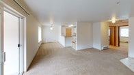 Located at 4525 S Warner St in Tacoma, Washington, Unit G68 is a single-floor residential unit offering a practical and comfortable layout. The open-concept living and dining area is finished with neutral wall-to-wall carpeting and features a ceiling fan with light fixture, a baseboard heating system, and a sliding glass door that leads to an outdoor patio, allowing natural light to fill the space. Wall-mounted sconce lighting adds a warm accent throughout the living area.

The kitchen is efficiently designed with white cabinetry, light-toned laminate countertops, a white electric coil range with overhead ventilation, and patterned vinyl tile flooring. A set of natural wood-toned bi-fold doors provides access to a pantry or storage closet, maximizing utility within the kitchen space.

The unit includes multiple bedrooms, each carpeted and featuring baseboard heaters and windows with blinds that bring in natural light and outdoor views of surrounding greenery. One bedroom includes access to a dedicated walk-in closet with built-in hanging rods, offering ample storage. The bedrooms are well-proportioned and versatile in their use. Overall, the unit presents a clean, neutral palette throughout, making it a functional and move-in ready residential space in Tacoma.