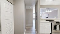 Located at 242 Main St in Hartford, CT, this well-appointed two-bedroom, two-bathroom residence offers a thoughtfully designed single-floor layout. The open-concept living and kitchen area serves as the heart of the home, where light wood-style flooring flows throughout, creating a clean, cohesive aesthetic. The kitchen is equipped with stainless steel appliances including a full-size refrigerator and dishwasher, white shaker cabinetry, a white countertop, and a stylish tile backsplash. A breakfast bar with pendant lighting connects the kitchen to the living area, providing a casual dining and entertaining space. The living room is bright and airy, highlighted by a wall of large windows fitted with blinds that frame views of the surrounding Hartford streetscape, allowing generous natural light to fill the space. Both bedrooms feature plush carpeting, individual windows, and neutral-toned walls that lend a calm, restful atmosphere. The primary bedroom offers a comfortable footprint with ample room. Each of the two bathrooms is finished with light wood-style flooring, a white vanity with an illuminated mirror or standard mirror, and a tub-shower combination with tile surround. The overall design is modern and neutral, creating a move-in ready space in the heart of Hartford.