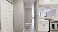 Located at 242 Main St in Hartford, CT, this well-appointed two-bedroom, two-bathroom residence offers a thoughtfully designed single-floor layout. The open-concept living and kitchen area serves as the heart of the home, where light wood-style flooring flows throughout, creating a clean, cohesive aesthetic. The kitchen is equipped with stainless steel appliances including a full-size refrigerator and dishwasher, white shaker cabinetry, a white countertop, and a stylish tile backsplash. A breakfast bar with pendant lighting connects the kitchen to the living area, providing a casual dining and entertaining space. The living room is bright and airy, highlighted by a wall of large windows fitted with blinds that frame views of the surrounding Hartford streetscape, allowing generous natural light to fill the space. Both bedrooms feature plush carpeting, individual windows, and neutral-toned walls that lend a calm, restful atmosphere. The primary bedroom offers a comfortable footprint with ample room. Each of the two bathrooms is finished with light wood-style flooring, a white vanity with an illuminated mirror or standard mirror, and a tub-shower combination with tile surround. The overall design is modern and neutral, creating a move-in ready space in the heart of Hartford.