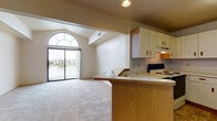 Located at 9275 S Orchard Park Cir in Oak Creek, Wisconsin, this single-floor unit offers a thoughtfully designed open-concept layout that seamlessly connects the kitchen and living areas. The living space is highlighted by soaring vaulted ceilings and a striking arched window above sliding glass doors, which open to a private balcony overlooking scenic outdoor surroundings. Neutral-toned carpeting runs throughout the main living and bedroom areas, contributing to a warm and cohesive feel.

The kitchen is equipped with ample white cabinetry accented by warm wood-toned hardware, offering generous storage and counter space. A raised breakfast bar provides a natural divide between the kitchen and the living area. An electric range and under-cabinet ventilation hood complete the functional cooking space, which features durable tile flooring.

The bathroom includes a wide vanity with a single sink, a large mirror, and tile flooring, providing a clean and practical layout. The bedroom is a generously sized, light-filled room with carpeted flooring and a window that allows natural light to flow in. Overall, this unit combines functional design with architectural character, making it a comfortable and practical living space in Oak Creek.