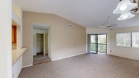 Located at 1088 West Granada Boulevard in Ormond Beach, Florida, this single-story residence offers a well-organized layout with two bedrooms, two bathrooms, and a thoughtfully designed floor plan. The living and dining areas are open and airy, highlighted by vaulted ceilings, plush carpeting, and a ceiling fan. Large sliding glass doors lead to a private patio, filling the space with natural light and providing lush outdoor views. An additional window further brightens the living area, enhancing its welcoming ambiance. The kitchen features warm wood cabinetry, light countertops, a breakfast bar with a built-in sink, a range with overhead ventilation, and a refrigerator — all set over easy-care hard flooring. Both bedrooms are carpeted and equipped with ceiling fans, natural light from windows, and generous closet space; the primary bedroom includes dual closets for added storage convenience. The bathrooms are clean and functional, with wood-toned vanities, large mirrors, and bright lighting. Additional highlights include a laundry area, a utility room, a hallway, and five closets distributed throughout. With ample storage, comfortable living spaces, and a serene outdoor connection, this residence offers practical and comfortable Florida living.