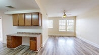 Located at 1300 Cherry St in Vicksburg, Mississippi, this two-bedroom, one-bathroom residence offers a practical and well-appointed single-floor layout. The open-concept kitchen and living area serves as the heart of the home, featuring wood-look plank flooring, warm neutral walls, and a ceiling fan that enhances air circulation. Large windows fitted with blinds allow abundant natural light to fill the living space, creating a bright and welcoming atmosphere.

The kitchen is well-equipped with warm-toned wood cabinetry, granite-style countertops, and a full suite of stainless steel appliances including a dishwasher, microwave, and electric range. A peninsula counter extends into the living area, providing additional prep and serving space.

The two bedrooms are finished with plush carpeting and feature generously sized windows that bring in natural light and views of the surrounding neighborhood. The primary bedroom includes a ceiling fan and closet access.

The bathroom is finished with large-format tile flooring and includes a vanity with granite-style countertops, matching wood cabinetry, a lighted mirror, and a tiled shower/tub combination. Clean white walls and coordinated fixtures give the bathroom a tidy, functional character throughout.
