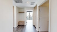 Located in the heart of downtown San Diego on Columbia Street, this high-rise residence offers a striking blend of modern design and urban living. The open-concept living area is anchored by dramatic floor-to-ceiling windows and a distinctive exposed concrete column, flooding the space with natural light and framing sweeping panoramic views of the San Diego skyline. Wide-plank hardwood flooring flows throughout, adding warmth to the contemporary aesthetic.

The kitchen is thoughtfully designed with flat-front light wood cabinetry, a white waterfall-edge island that doubles as a dining surface, a subway tile backsplash, stainless steel appliances, and globe pendant lighting — all complemented by expansive city views from the adjacent windows.

The primary bedroom features built-in light wood cabinetry for ample storage and large floor-to-ceiling windows that continue the skyline panorama. A secondary bedroom offers clean white walls and hardwood flooring, while a hallway entry area includes built-in shelving and a bench. The three bathrooms are finished with tile flooring, stone-tiled walk-in showers with glass enclosures, and modern vanities. A private balcony provides direct outdoor access from the living area, completing this polished urban retreat.