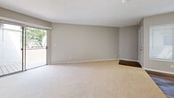 Located at 1256 W Arrow Hwy in Upland, CA, this single-story residence offers a well-organized 1-bedroom, 2-bathroom layout designed for efficient and comfortable living. The open-concept main area seamlessly integrates the living room, dining space, and kitchen, creating a cohesive and functional floor plan. Soft carpeting covers the living and bedroom areas, while wood-style flooring runs through the kitchen and bathrooms, providing a clean contrast in materials. The living room is brightened by natural light streaming through a sliding glass door that opens to a private outdoor area, and a ceiling fan adds both comfort and style. The kitchen features white cabinetry, a built-in microwave, electric range, and a peninsula with a stone-topped breakfast bar that overlooks the main living space, illuminated by a skylight panel above. The spacious bedroom also benefits from its own sliding glass door access to the outdoors and includes a dedicated closet. Two full bathrooms, each with wood-style flooring, offer convenience and privacy. Additional closet space throughout provides ample storage. Neutral tones and textured ceilings give the space a clean, move-in ready aesthetic suited to a variety of lifestyles.