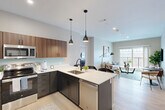 Located at 19 Hemans St in Worcester, MA, this thoughtfully designed 2-bedroom, 2-bathroom residence offers a well-appointed single-floor layout. The open-concept kitchen and dining area serves as the heart of the home, showcasing two-tone cabinetry with rich walnut upper cabinets and dark lower cabinets, crisp white quartz countertops, a teal glass backsplash, and a full suite of stainless steel appliances. A peninsula with seating provides both casual dining and additional prep space, while sleek pendant lights add a modern touch. Light wood-look flooring flows throughout the main living areas. The living room is bright and welcoming, highlighted by large windows and a sliding glass door that opens to a private balcony with scenic outdoor views. Both bedrooms are carpeted and feature windows that invite natural light; the generously sized primary bedroom offers a comfortable retreat. The two bathrooms are finished with large-format gray tile, dark cabinetry, and white countertops, with one featuring a soaking tub. Additional conveniences include in-unit laundry, a utility room, and four closets providing ample storage throughout.