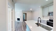 This contemporary 740 square foot apartment in Cedar Park, TX offers a thoughtful layout with three bedrooms and one bathroom. The heart of the home is an open-concept living and kitchen area, showcasing a sleek, updated kitchen with white cabinetry, stainless steel appliances, and a convenient island with a sink. The living room features a charming fireplace, adding warmth and character to the space.

Throughout the apartment, you'll find durable wood-look flooring and neutral-toned walls, creating a bright and airy ambiance. The bedrooms are well-proportioned, with the primary bedroom measuring 140 square feet. Each bedroom includes a closet for storage, and ceiling fans provide comfort and air circulation.

The bathroom boasts a modern design with a white tiled surround in the shower/tub combo. For added convenience, there's an in-unit laundry area with a top-loading washer. Large windows in the bedrooms allow for ample natural light, while white window blinds offer privacy when needed.

This efficient single-story layout maximizes the use of space, making it an ideal home for those seeking a balance of comfort and functionality in a contemporary setting.