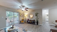 Located at 100 Windmont Dr NE in Brookhaven, GA, this single-floor, one-bedroom, one-bathroom residence offers a thoughtfully designed layout with consistent light wood-tone flooring throughout. The living room serves as the heart of the home, featuring a ceiling fan, a textured ceiling, and a sliding glass door that opens to a private balcony overlooking mature, verdant trees—flooding the space with natural light. The open flow connects the living area to a dedicated dining nook, accented by chair rail molding and ample wall space. The galley-style kitchen is equipped with white cabinetry, granite-style countertops, a subway tile backsplash, and stainless steel appliances including a range, microwave, and refrigerator, alongside a pantry with bifold doors. The bedroom is a comfortable retreat with a ceiling fan, a window dressed with blinds for natural light control, and generous floor space. The bathroom features a granite-topped vanity with white cabinetry, a tub-shower combination with tile surround, and matching flooring. Throughout the residence, neutral wall tones and cohesive finishes create a clean, welcoming ambiance ideal for everyday living.