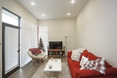 This single-floor unit offers a thoughtfully designed layout that balances comfort and functionality. The open-concept kitchen serves as a central hub, featuring rich warm-toned cabinetry, stainless steel appliances including a refrigerator, microwave, and range, and a generous white quartz island with seating for multiple bar-height chairs. Pendant lighting above the island adds a polished finishing touch, while wood-look flooring grounds the space with warmth and durability.

The living area is an intimate, light-filled room with neutral walls, large windows with blinds, and smooth wood-look flooring that flows cohesively from the kitchen. The space is well-suited for relaxed everyday living.

Two bedrooms provide comfortable retreats, both featuring plush carpet, tall ceilings, and large windows that allow ample natural light. Each room offers sufficient space for full bedroom furniture arrangements, and the layout allows for personalization.

Two bathrooms serve the unit, each featuring warm wood-toned cabinetry, white countertops, and wood-look flooring. One bathroom includes a wide vanity with a large mirror, while the other provides a similarly clean and functional design. Both are finished with neutral tones that complement the overall aesthetic of the unit.