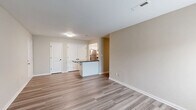 Located at 14505 Old Courthouse Way in Newport News, VA, this well-appointed 2-bedroom, 3-bathroom single-floor residence offers a clean, modern aesthetic throughout. The open-concept living and kitchen area serves as the heart of the home, featuring light-toned hardwood-style flooring that flows seamlessly throughout the main living spaces. The kitchen is equipped with stainless steel appliances—including a range, dishwasher, and refrigerator—complemented by white cabinetry, dark granite-style countertops, a range hood, and a peninsula that doubles as a breakfast bar. The living room is bright and inviting, with access to a private balcony through glass-panel doors that allow natural light to fill the space. The spacious primary bedroom features plush carpeting, a generous double-door closet, and a natural light source through a sizable window. The second bedroom also features carpet and hardwood-style flooring options, providing flexible use. The three bathrooms are finished in crisp white tones, with one offering a full soaking tub and shower combination, and another featuring a vanity with a large mirror and dark fixture accents. Neutral wall tones and clean white trim tie the entire home together, creating a cohesive and move-in-ready living environment.