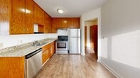 Located in Maplewood, MN, this single-floor unit offers three bedrooms, one bathroom, and a practical layout designed for comfortable everyday living. Light-toned hardwood flooring flows consistently throughout the space, creating a clean, cohesive look.

The spacious primary bedroom features dual windows with wood trim, a ceiling fan, baseboard heating, and a wall-mounted air conditioning unit, ensuring year-round comfort. The two additional bedrooms are well-proportioned, each with hardwood floors, wood-trimmed windows, ceiling fans, and closet access.

The kitchen is outfitted with warm oak cabinetry, granite-look countertops, a stainless steel dishwasher, electric range, and refrigerator—providing ample storage and functional workspace. It opens toward the hallway, allowing for easy flow through the unit.

The full bathroom features mosaic tile flooring, a tub-shower combination with white tile surround, a wood-vanity with sink, and a mirrored medicine cabinet above.

The bright living area benefits from large windows with vertical blinds that invite natural light, complemented by light walls and gleaming hardwood floors. With four closets distributed throughout, storage is a clear priority. Baseboard heating is present throughout, keeping the unit efficient during Minnesota winters.