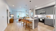 Located at 9895 W 58th Ave in Arvada, Colorado, this well-appointed two-bedroom, two-bathroom single-floor residence offers a contemporary open-concept design with consistent light wood-style flooring and a clean, modern aesthetic throughout. The kitchen is a standout feature, showcasing gray shaker cabinetry, stainless steel appliances, white quartz countertops, and a central island with bar seating illuminated by pendant lighting — flowing seamlessly into the bright and welcoming living room, which benefits from large windows that invite natural light. The primary bedroom is a comfortable retreat with a ceiling fan, generous natural light, and access to a well-appointed en-suite bathroom featuring dual sinks with gray cabinetry, white quartz countertops, a large mirror, and a glass-enclosed walk-in shower with marble-style tile. The second bedroom and bathroom maintain the same refined design language. Four closets, including a spacious walk-in, provide ample storage. A dedicated laundry area and a hallway complete the functional layout. The overall ambiance is modern and cohesive, with bright white walls and quality finishes that create an inviting and polished living environment.