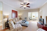 Located at 3150 Skinner Mill Rd in Augusta, GA, this well-appointed single-story home offers 2 bedrooms, 2 bathrooms, and a versatile layout designed for comfortable everyday living. The open-concept living and dining areas are highlighted by hardwood flooring, crown molding, and ceiling fans that lend a classic, polished feel. The living room features a warm, inviting atmosphere with generous natural light and a seamless connection to the adjoining dining area, which is complemented by an elegant pendant light fixture. The kitchen is framed by architectural columns and features rich wood cabinetry, granite countertops, stainless steel appliances, recessed lighting, and a breakfast bar with barstool seating — ideal for casual dining. A bright, sunlit office with large windows and French doors provides a quiet workspace or flex room. The spacious primary bedroom is carpeted and includes a ceiling fan, while both bathrooms are finished with tile flooring, granite-topped vanities, and shower-tub combinations. A dedicated laundry room accommodates a full-size washer and dryer alongside additional cabinetry. With six closets spread throughout, storage is plentiful. The home's neutral palette and cohesive finishes create a refined, move-in-ready environment.
