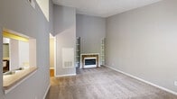 Located at 3800 Meriwether Dr in Durham, NC, this well-appointed one-bedroom, one-bathroom residence offers a thoughtfully designed single-floor layout. The combined kitchen and living area forms the heart of the home, where vaulted ceilings create an impressive sense of openness and volume. The living room is anchored by a stone-surround fireplace flanked by built-in shelving, adding both warmth and character. Natural light filters through a large window, brightening the neutral-toned, carpeted space. The kitchen features rich dark-wood cabinetry, warm hardwood-style flooring, light countertops, a stainless steel dishwasher, and a full-size refrigerator, with a convenient pass-through window connecting it to the living area. The bedroom is generously sized, with vaulted ceilings, plush carpet, and sliding glass doors that open directly onto a private balcony with outdoor views—a serene retreat. The bathroom offers a clean, functional design with a full soaking tub/shower combo and a well-lit vanity with mirror. A dedicated laundry room with hardwood-style flooring, full-size washer and dryer, and overhead cabinetry adds exceptional convenience. A closet completes this efficient and comfortable home.