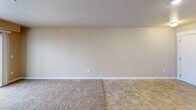 Located in Airway Heights, Washington, this well-appointed 3-bedroom, 2-bathroom residence offers a comfortable and functional layout across a single floor. The open-concept living, dining, and kitchen area serves as the heart of the home, featuring neutral-toned walls, plush carpeting, and tile flooring that transitions seamlessly between spaces. A wall-mounted HVAC unit keeps the living area climate-controlled, while sliding glass doors lead to a private balcony, filling the room with natural light and offering outdoor views.

The kitchen is equipped with warm wood cabinetry, black appliances including a range, microwave, and refrigerator, a breakfast bar, a pantry, and track lighting overhead. The generous primary bedroom includes a closet and baseboard heating, while the two additional bedrooms are carpeted and feature natural light from windows. Each bedroom offers convenient closet storage, with four closets distributed throughout the unit.

The two bathrooms are finished with tile flooring and warm neutral tones. One features a full tub-shower combination, while the other includes a wood-toned vanity with an integrated sink and mirror. Two hallways connect the spaces efficiently, completing this practical and well-organized home.
