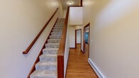 Located at 177–183 Windermere Ave in Ellington, Connecticut, this multi-floor property spans three levels and offers a thoughtfully designed layout with quality finishes throughout. The main living level features warm hardwood flooring that flows through the hallways and common areas, complemented by rich cherry wood trim and baseboards. The kitchen is a standout, outfitted with stainless steel appliances, an island with dark granite countertops, a tile backsplash, and abundant cabinetry — all illuminated by recessed lighting. A dedicated laundry room with tile flooring and a washer and dryer adds everyday convenience. The upper level hosts generously sized bedrooms, including a primary suite with carpet, a ceiling fan, multiple windows for natural light, and access to a large walk-in closet with extensive wire shelving. Additional bedrooms feature hardwood floors, crown molding, and natural light from double-pane windows. A full bathroom with tile flooring, a granite-top vanity, and a shower/tub combo serves the upper floor. The staircase connecting all levels is finished with carpet treads and a polished wood railing. The lower level offers an open, unfinished basement with concrete walls and small windows, providing ample storage or potential for future finishing.