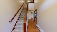 Located at 177–183 Windermere Ave in Ellington, Connecticut, this multi-floor property spans three levels and offers a thoughtfully designed layout with quality finishes throughout. The main living level features warm hardwood flooring that flows through the hallways and common areas, complemented by rich cherry wood trim and baseboards. The kitchen is a standout, outfitted with stainless steel appliances, an island with dark granite countertops, a tile backsplash, and abundant cabinetry — all illuminated by recessed lighting. A dedicated laundry room with tile flooring and a washer and dryer adds everyday convenience. The upper level hosts generously sized bedrooms, including a primary suite with carpet, a ceiling fan, multiple windows for natural light, and access to a large walk-in closet with extensive wire shelving. Additional bedrooms feature hardwood floors, crown molding, and natural light from double-pane windows. A full bathroom with tile flooring, a granite-top vanity, and a shower/tub combo serves the upper floor. The staircase connecting all levels is finished with carpet treads and a polished wood railing. The lower level offers an open, unfinished basement with concrete walls and small windows, providing ample storage or potential for future finishing.