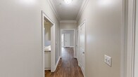 Located at 244 Kyser Blvd in Madison, Alabama, this single-floor residence offers three bedrooms, three bathrooms, and a thoughtfully arranged layout. The living room features warm neutral-toned walls, plush carpet, a ceiling fan, and a textured ceiling, with natural light flowing in through large windows and a glass door. It connects seamlessly to the kitchen, which is outfitted with white cabinetry, granite-style countertops, a classic subway tile backsplash, and white appliances including a refrigerator, range, and built-in microwave. Wood-look hard flooring runs through the kitchen and main areas, adding warmth and cohesion throughout. The bedrooms are carpeted and finished with the same neutral palette, offering a calm and comfortable atmosphere. The primary bedroom includes access to a walk-in closet equipped with wire shelving systems for organized storage. The bathrooms feature wood-look tile flooring, white vanities with stone-top counters, and tub-shower combinations. A dedicated laundry room with washer/dryer hookups and built-in shelving adds everyday convenience. The hallway connects all areas efficiently, completing this well-organized and functional home.