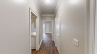 Located at 244 Kyser Blvd in Madison, Alabama, this single-floor residence offers three bedrooms, three bathrooms, and a thoughtfully arranged layout. The living room features warm neutral-toned walls, plush carpet, a ceiling fan, and a textured ceiling, with natural light flowing in through large windows and a glass door. It connects seamlessly to the kitchen, which is outfitted with white cabinetry, granite-style countertops, a classic subway tile backsplash, and white appliances including a refrigerator, range, and built-in microwave. Wood-look hard flooring runs through the kitchen and main areas, adding warmth and cohesion throughout. The bedrooms are carpeted and finished with the same neutral palette, offering a calm and comfortable atmosphere. The primary bedroom includes access to a walk-in closet equipped with wire shelving systems for organized storage. The bathrooms feature wood-look tile flooring, white vanities with stone-top counters, and tub-shower combinations. A dedicated laundry room with washer/dryer hookups and built-in shelving adds everyday convenience. The hallway connects all areas efficiently, completing this well-organized and functional home.