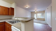 This single-floor residence offers a practical and well-organized layout that balances common living spaces with private rooms. The kitchen is equipped with white appliances, including an electric range, over-the-range microwave, and refrigerator, all complemented by warm medium-toned wood cabinetry and granite-look countertops. A peninsula with a double sink separates the kitchen from the living area, creating an open and connected feel. The living room features a ceiling fan, hardwood-style flooring that transitions into carpet, and a glass door that invites natural light and outdoor views.

The bedrooms are carpeted and well-proportioned, each featuring ceiling fans and windows with blinds that provide natural light and views of surrounding greenery. The neutral wall tones throughout contribute to a calm, cohesive atmosphere.

Two bathrooms are present, each featuring a tiled tub-shower combination, a single vanity with warm wood cabinetry, a wall-mounted medicine cabinet, and hardwood-style flooring. A dedicated laundry area with connections is also included, along with an electrical panel conveniently located nearby. The overall design is functional, clean, and move-in ready.