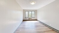 Located at 76 Webster Street in Hartford, Connecticut, this one-bedroom, one-bathroom unit offers a practical and well-appointed single-floor layout. Light-toned wood flooring runs throughout the space, creating a clean and cohesive look. The open kitchen and living area form the heart of the unit, where the kitchen stands out with gray shaker-style cabinetry, a mosaic tile backsplash, dark countertops, and stainless steel appliances including a full-size refrigerator and gas range. A textured ceiling adds dimension to the living area. The spacious bedroom features large windows with views of surrounding trees, allowing generous natural light to fill the room. Baseboard heating units are present throughout. The bathroom is elegantly finished with marble-style tile walls, a decorative mosaic border, a soaking tub with shower, a pedestal sink, and a window that brings in additional natural light. Neutral wall tones throughout the unit provide a versatile backdrop suitable for a variety of interior styles. The overall ambiance is bright, functional, and well-maintained, making it a comfortable residence in the heart of Hartford.