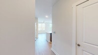 Located at 5441 Greenwich Rd in Virginia Beach, VA, this well-appointed 2-bedroom, 2-bathroom single-floor residence offers a thoughtfully designed layout with modern finishes throughout. The open-concept kitchen and living area serves as the heart of the home, showcasing two-tone gray cabinetry, a white subway tile backsplash, recessed lighting, a central island with a light quartz countertop, and a full suite of stainless steel appliances including a French door refrigerator, electric range, built-in microwave, and dishwasher. Light-toned luxury vinyl plank flooring runs through the main living areas, complementing the bright, neutral color palette. The spacious living room features a ceiling fan with light fixture and a window that fills the space with natural light. Both bedrooms are carpeted for comfort, with large windows providing ample daylight and outdoor views. The primary bedroom is generously sized and includes access to a well-equipped closet with wire shelving systems. The bathrooms are finished with white vanities, modern fixtures, and a tiled walk-in shower with a sleek glass sliding door. A dedicated laundry room houses a full-size Whirlpool washer and dryer with overhead wire shelving for additional storage.