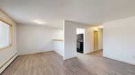 This 750 square foot apartment in Lakeville, Minnesota offers a practical and modern living space. The single-floor layout comprises two bedrooms, one bathroom, and an open-concept living and kitchen area. The primary bedroom, measuring 120 square feet, provides a comfortable retreat.

The living area features wood-look flooring, creating a contemporary aesthetic that flows into the kitchen. The kitchen boasts white cabinetry, contrasting dark appliances, and a wooden breakfast bar, perfect for casual dining or additional prep space. Fluorescent lighting in the kitchen ensures a well-lit workspace.

Both bedrooms are carpeted for comfort, with the larger room offering two windows that flood the space with natural light. Baseboard heating units are present throughout, ensuring warmth during Minnesota's cold winters. The bathroom showcases a modern design with a white vanity, toilet, and shower/tub combination, complemented by wood-look flooring.

Storage solutions include sliding closet doors in the bedrooms and ample kitchen cabinetry. The apartment's neutral color palette, primarily in whites and light grays, creates a bright and airy atmosphere throughout. This efficient layout maximizes the use of space, making it an ideal choice for those seeking a compact yet functional living arrangement.