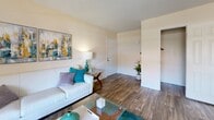 This well-appointed one-bedroom, one-bathroom unit at 4201 W Rochelle Ave in Las Vegas, NV offers a functional and comfortable layout across a single floor. The living room serves as the heart of the home, featuring wood-style flooring, a textured ceiling, and a sliding glass door that opens to a private patio, allowing natural light to fill the space. A dedicated dining area adjacent to the living room provides an ideal space for meals and entertaining. The galley-style kitchen is equipped with stainless steel appliances — including a refrigerator, range, microwave, and dishwasher — complemented by white cabinetry, dark granite-style countertops, and a window that brings in additional natural light. The spacious bedroom features plush carpeting, a closet with sliding doors, a window for natural light, and a textured ceiling. The full bathroom includes a combined tub and shower, a vanity with granite-style countertops, white cabinetry, and wood-style flooring. A dedicated laundry area houses a full-sized, in-unit washer and dryer, adding everyday convenience. Throughout the unit, neutral wall tones create a clean, versatile backdrop.