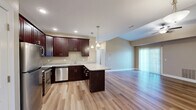 This well-appointed 2-bedroom, 2-bathroom home on Southwestern Boulevard in Buffalo, NY offers a thoughtfully designed single-floor layout. The open-concept kitchen and living area serves as the heart of the home, featuring rich dark-wood cabinetry, granite countertops, a center island with pendant lighting, and stainless steel appliances. Light hardwood flooring flows throughout the main living spaces, complementing the vaulted ceilings and ceiling fan that enhance the sense of openness. The living room is anchored by a classic white-mantled fireplace and benefits from natural light through a sliding glass door fitted with vertical blinds. Both bedrooms are carpeted for comfort and include ceiling fans and closet storage — one featuring a double sliding-door closet. The primary bedroom is generously sized with a natural window view. The two bathrooms are finished consistently with dark wood vanities and granite countertops; one includes a tub-shower combo, while the other features a framed glass sliding shower enclosure with wood-look flooring. Neutral warm tones throughout create a cohesive, move-in-ready ambiance suited for comfortable everyday living.