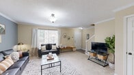 Located at 110 International Dr in Athens, GA, this two-story home offers four bedrooms and four bathrooms across two well-proportioned floors. The main level features a welcoming living room adorned with crown molding, a textured ceiling, and neutral-toned carpet. Natural light filters in through a front-facing window, creating a bright and open atmosphere. A staircase with white balusters leads to the upper level, while the open sightline connects the living area to the dining space and kitchen. The galley-style kitchen is outfitted with warm wood cabinetry, dark granite-style countertops, a stainless steel sink, and hardwood-style flooring, with a secondary door providing convenient access. The upper floor houses the bedrooms, each carpeted and finished with neutral walls. The primary bedroom includes a walk-in closet and direct access to its own bathroom. Additional bedrooms are comfortably sized with natural light from individual windows. The four bathrooms are clean and functional — some featuring tub-shower combos with tile flooring, while others include standalone glass-enclosed showers with wood-accented vanities. Throughout the home, a consistent warm, neutral palette contributes to a cohesive and practical living environment.