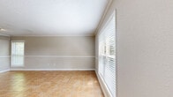 This single-story, one-bedroom, one-bathroom home in Houston, Texas offers a practical and comfortable layout with consistent warm-toned tile flooring throughout every room. The living area is a welcoming space featuring crown molding, neutral beige walls, and a large window fitted with blinds that allows generous natural light to fill the room. A ceiling fan adds to the comfort of the space, while clean white baseboards and trim provide a crisp, finished look throughout.

The kitchen is efficiently designed in a galley style, featuring gray cabinetry with white countertops, a stainless steel sink, and full-size stainless steel appliances including a refrigerator and range. The layout makes efficient use of the available space while keeping the area functional and tidy.

The bedroom is a well-proportioned retreat, brightened by a large window with outdoor views and complemented by two six-panel white doors leading to a dedicated closet, offering ample storage. Crown molding continues into this room, maintaining design consistency throughout the home.

The bathroom includes a single-sink vanity with a marble-style countertop, a full tub-shower combination with white tile surround, and warm tile flooring, presenting a clean and straightforward design. Textured walls throughout the home add a subtle tactile character to the overall aesthetic.