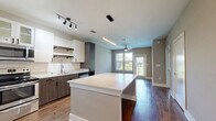 Located at 2470 Cheshire Bridge Rd NE in Atlanta, GA, this well-appointed one-bedroom, one-bathroom unit offers a thoughtfully designed open-concept layout with modern finishes throughout. Rich hardwood-style flooring anchors the main living areas, creating a warm and cohesive aesthetic. The kitchen is a standout feature, showcasing a large central island with quartz countertops, a striking mix of white upper cabinetry and dark wood-toned lower cabinets, subway tile backsplash, stainless steel appliances, and both pendant and track lighting. The kitchen flows seamlessly into the living area, which benefits from natural light through a large window and is finished with a ceiling fan. The spacious bedroom features plush carpeting, a ceiling fan, and a window with outdoor views of surrounding greenery, offering a calm retreat. The bathroom is elegantly appointed with a dual-sink vanity, dark wood cabinetry, a large framed mirror, and hardwood-style flooring that continues from the main areas. A dedicated walk-in closet with built-in wire shelving provides ample storage. The overall ambiance is clean, contemporary, and functional — ideal for modern urban living in Atlanta.